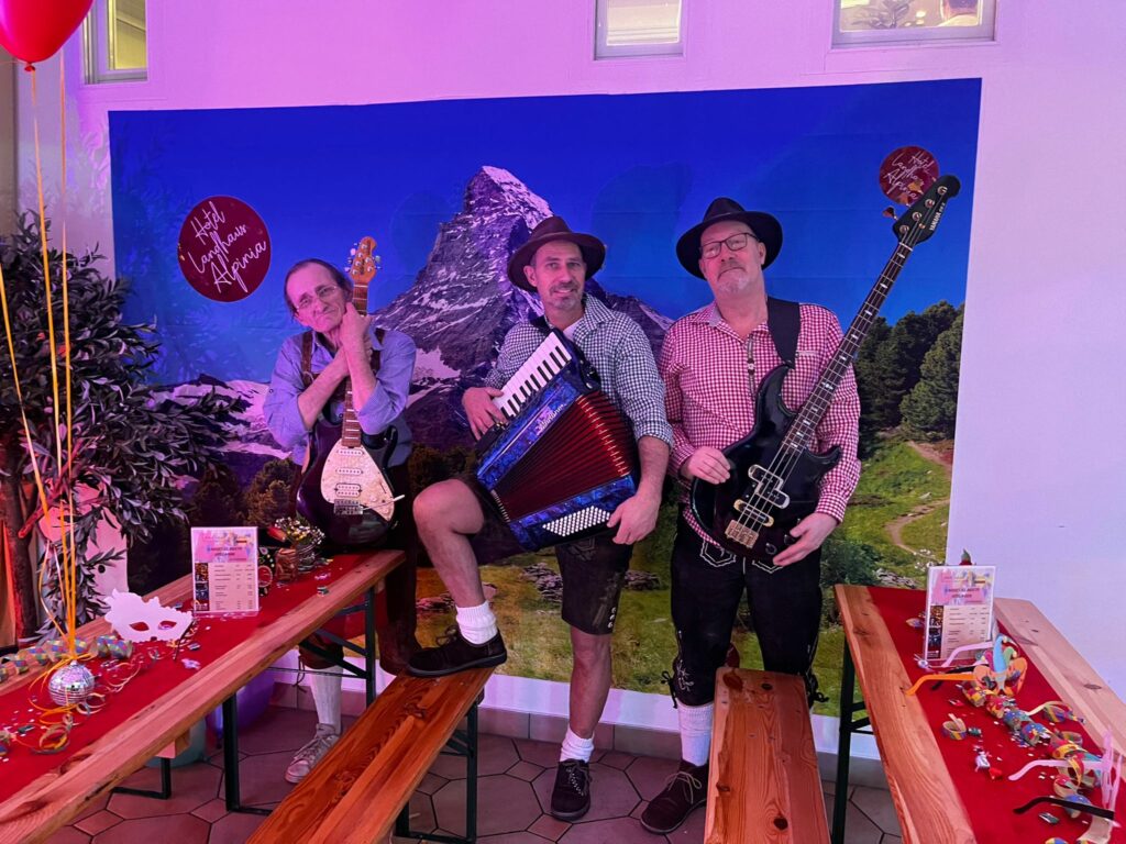 The Cheeky Bavarians performing live in traditional Bavarian costumes with brass and accordion at an Oktoberfest event in Berlin